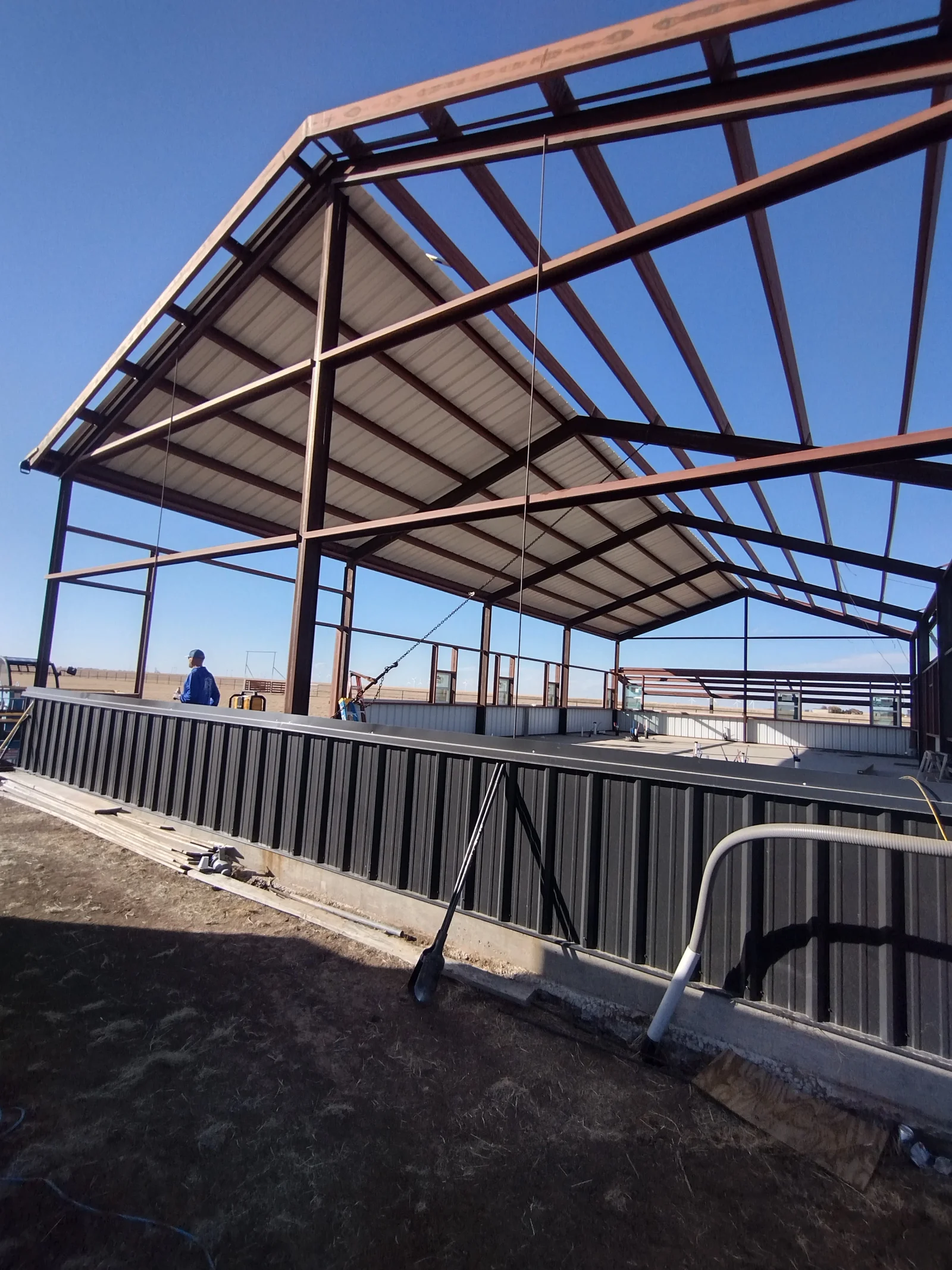 Steel frame structure with corrugated metal roof panels and metal siding walls under construction