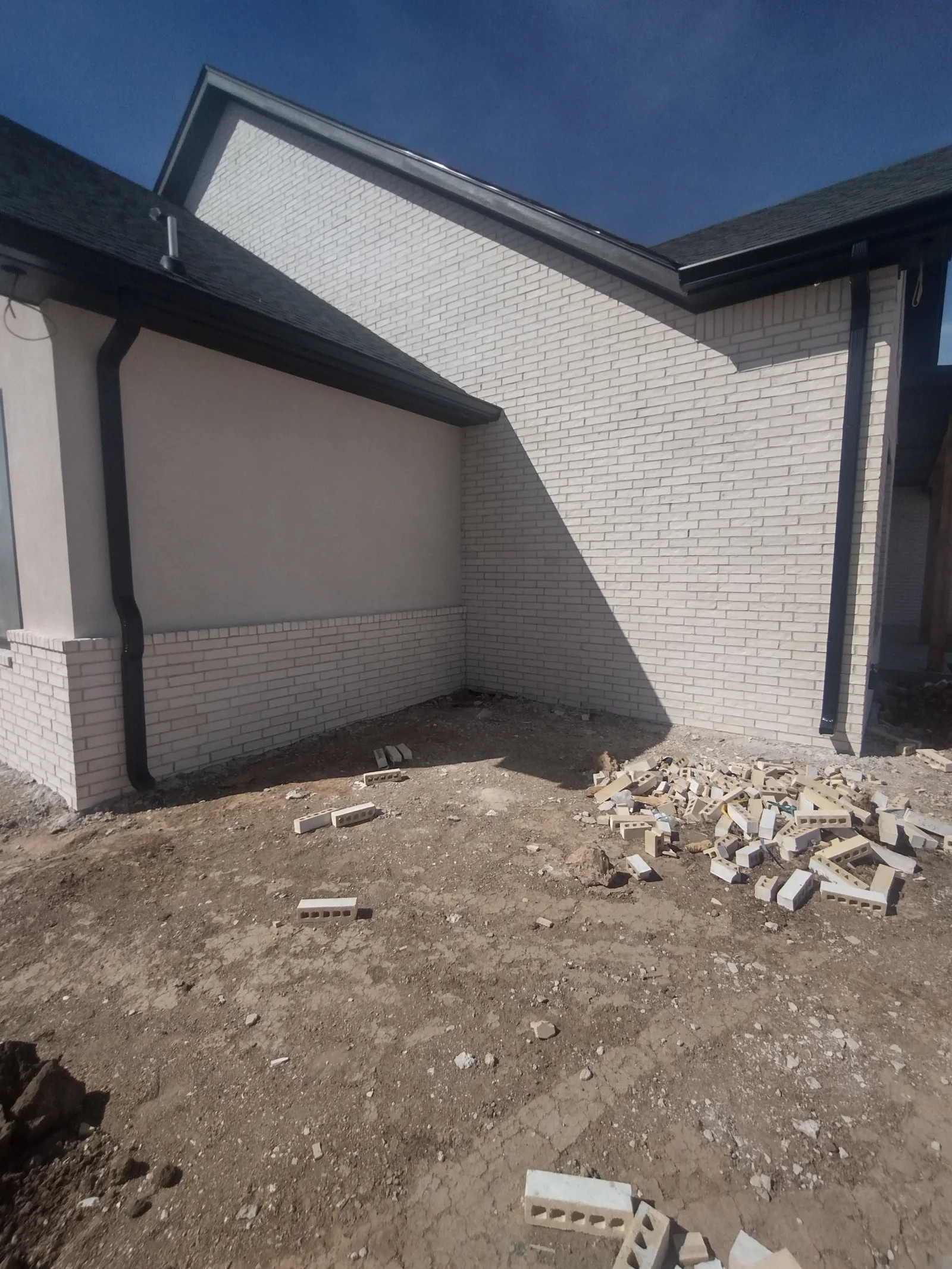 White brick addition with black soffit, fascia, and gutter system installation
