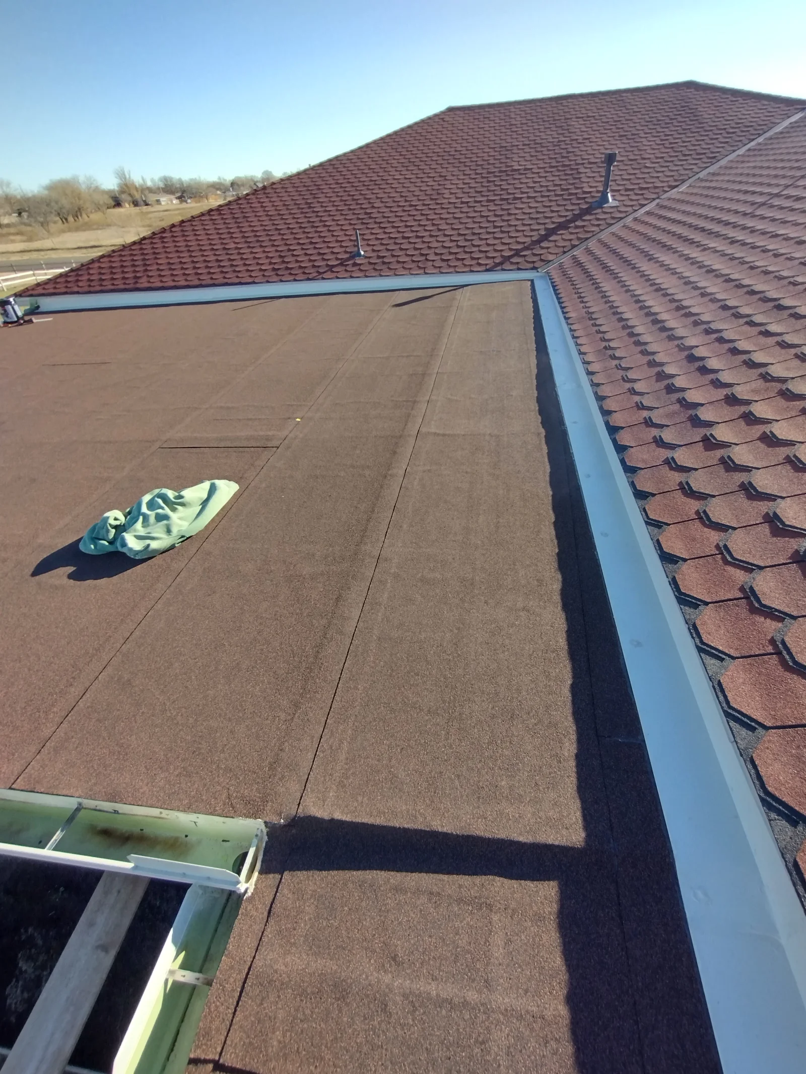 Burgundy architectural shingles with metal flashing and roof vents on residential home