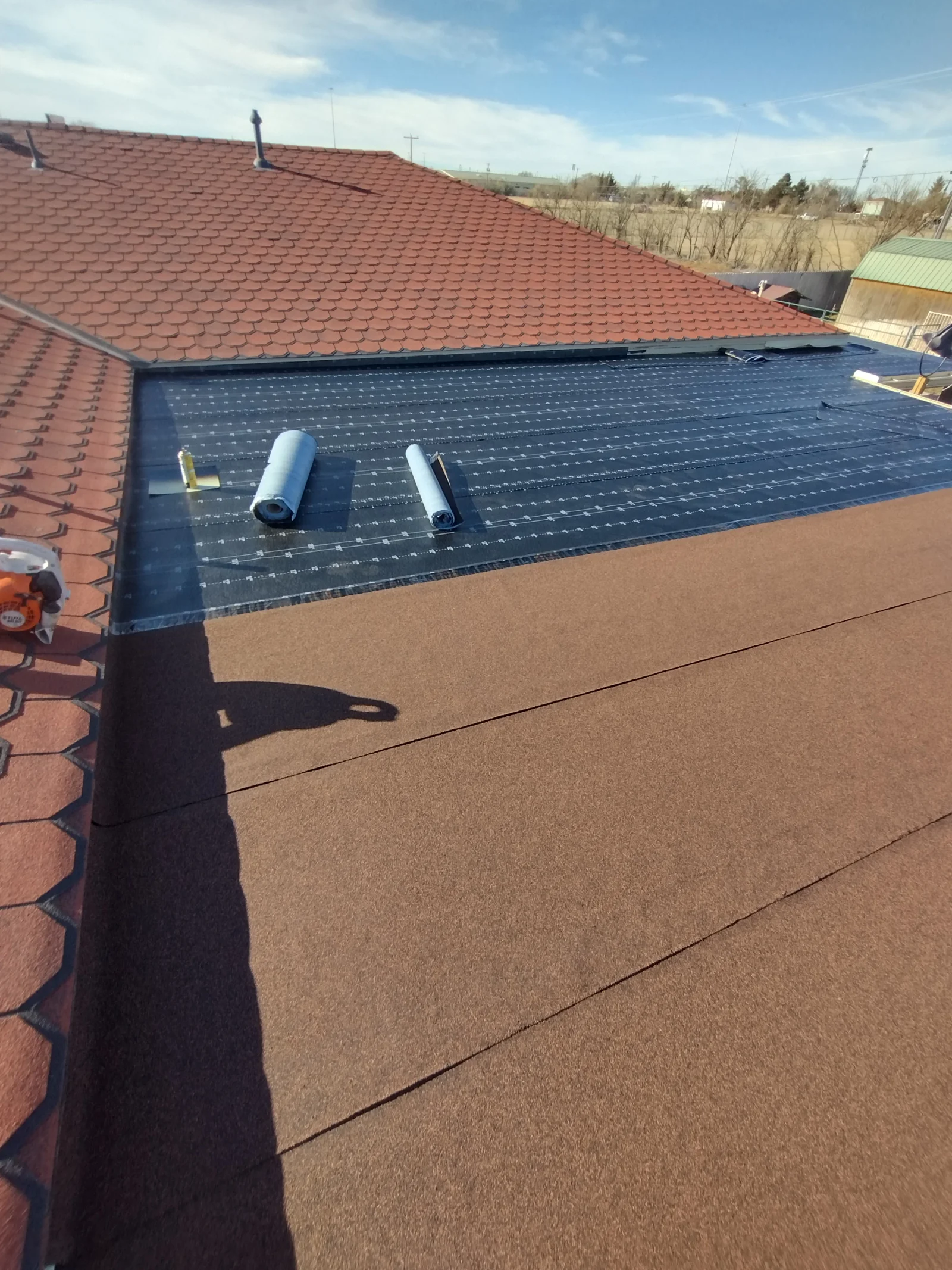 Dark TPO membrane flat roof with cork underlayment and roof vents during installation
