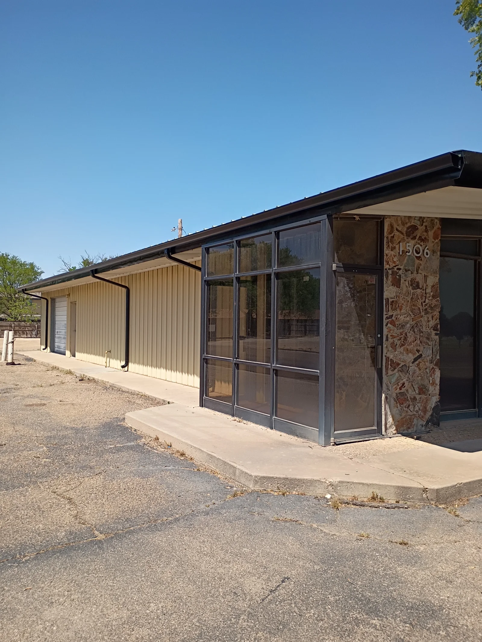 Dark metal standing seam roof with gutters, fascia, and covered patio structure